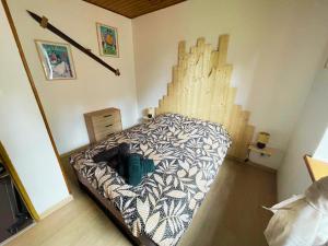 a bedroom with a bed with a wooden wall at Très bel appartement à 20 min de Gérardmer in Saulcy-sur-Meurthe