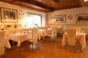 a dining room with white tables and chairs at Hotel Bölke in Wunstorf