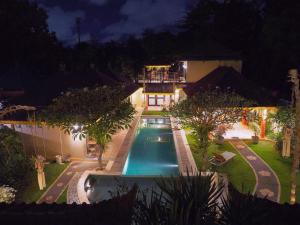 a house with a swimming pool at night at The Paradise Bali in Badung