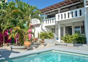 una casa con piscina y palmeras en Adults Only Casa Cactus - Stylish Boho Studios with Garden and Pool Access, en Puerto Escondido