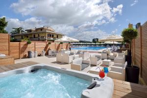 a swimming pool with a hot tub and lounge chairs at Hotel Ristorante Dante in Torgiano