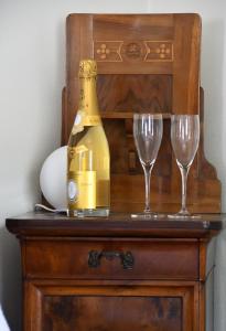 a bottle of champagne and two glasses on a dresser at Casa Alba, Blevio Lago di Como in Blevio