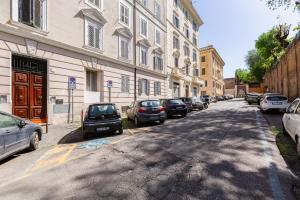 a street with cars parked on the side of a building at LuxurySistersHouse 2 min Colosseum in Rome
