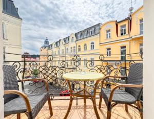 a patio with a table and chairs on a balcony at Boutique Hotel Romanza in Mariánské Lázně