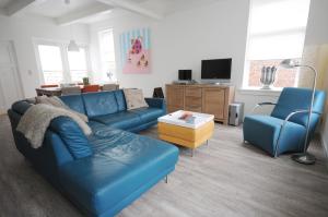 a living room with a blue couch and two chairs at Brink 3 Diever in Diever