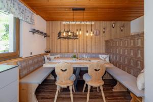 a dining room with a long table and two chairs at Almhütten Sonnblick & Almfried in Sonnenalpe Nassfeld
