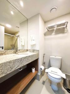 um banheiro com um vaso sanitário, uma pia e um espelho em Unihome Studio em Niterói