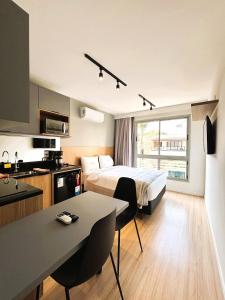 um quarto de hotel com uma cama e uma cozinha em Unihome Studio em Niterói