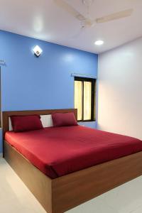 a bedroom with a red bed with a blue wall at The Elite Villa 2 Bhk in Panchgani