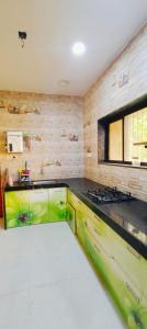 a kitchen with green cabinets and a stove at The Elite Villa 2 Bhk in Panchgani