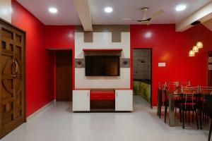 a dining room with red walls and a tv on the wall at The Elite Villa 2 Bhk in Panchgani