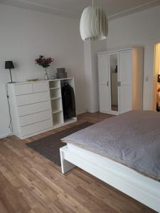 a white bedroom with a bed and a dresser at Wunderschönes Single Apartment in Berlin