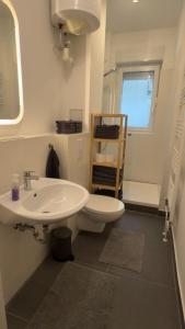 a bathroom with a white sink and a toilet at Wunderschönes Single Apartment in Berlin +3 photos