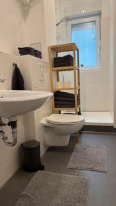 a bathroom with a white toilet and a sink at Wunderschönes Single Apartment in Berlin