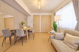 un salon avec un canapé, une table et des chaises dans l'établissement シャンブル南行徳201, à Tokyo
