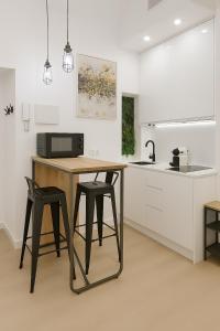 eine Küche mit einem Tisch, 2 Stühlen und einer Mikrowelle in der Unterkunft Tourist House Francos in Sevilla + 15 Fotos