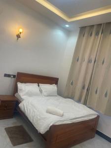 a bedroom with a large bed with white sheets at La Million Palace - Dodoma in Dodoma