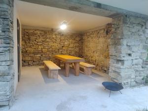 a picnic table and benches in a stone wall at Chalúpka pod Hradom Lednica 