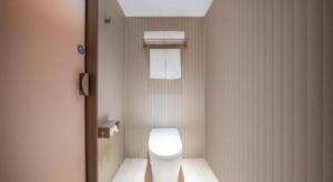 un bagno con un water bianco in una cabina di Hanting Hotel Zhangjiajie Tianmen Mountain Zhongshang Plaza a Zhangjiajie