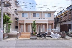 une maison avec deux vélos garés devant dans l'établissement シャンブル南行徳201, à Tokyo