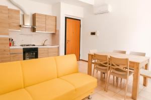 a living room with a yellow couch and a table at Via Milano 67 in Porto SantʼElpidio
