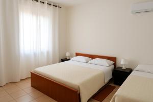 a bedroom with two beds and a window at Via Milano 67 in Porto SantʼElpidio +1 photo