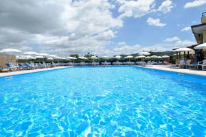 a large swimming pool with chairs and umbrellas at Hotel Ristorante Dante in Torgiano