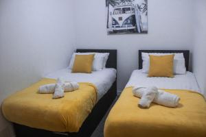 two beds sitting next to each other in a room at Family-Friendly 3-Bed House in Swansea in Swansea