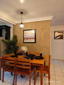 una sala da pranzo con tavolo e sedie in legno di Luxhomme Baguio Guest Homestay with Balcony a Baguio