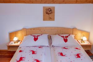 a bed with two pillows with red crabs on it at Almhütten Sonnblick & Almfried in Sonnenalpe Nassfeld