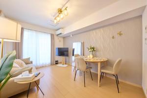 un salon avec une table, des chaises et un canapé dans l'établissement シャンブル南行徳201, à Tokyo