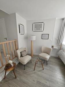 a living room with two chairs and a bed at Studio indépendant Le Vast in Le Vast