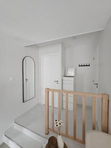 a white room with a staircase and a mirror at Studio indépendant Le Vast in Le Vast +2 photos