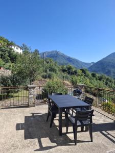 a black table and chairs on a patio with mountains at La casa sotto al volto in Licciana Nardi