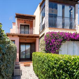 a house with purple flowers on the side of it at Green Residence Bados Mare in Olbia