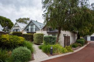 a white house with a tree and bushes at Coastal Elegance Relaxed Stay in Broadwater in Broadwater
