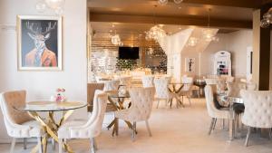 a dining room with tables and white chairs and a table and chairsktop at The Feather's Hotel Newquay in Newquay