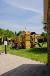 a playground with wooden play equipment in the grass at Hoeve de Binnenplaets Schimmert in Schimmert