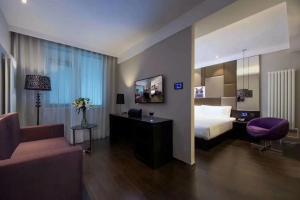 una stanza d'albergo con un letto e una sedia di Orange Hotel Beijing Guangming Bridge a Pechino