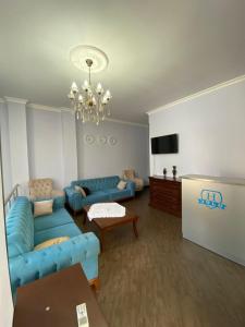 un salon avec des canapés bleus et une télévision dans l'établissement Hotel AISI, à Koutaïssi