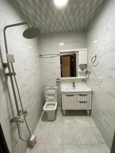 une salle de bain blanche avec un lavabo et des toilettes dans l'établissement Hotel AISI, à Koutaïssi