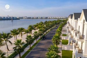 a street lined with palm trees next to a body of water at Moon Homestay 1717 in Gia Lâm Pho