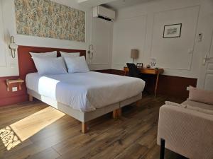 a bedroom with a large bed and a couch at La Suite Gignac in Gignac