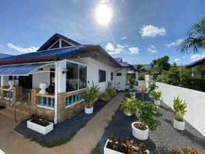 ein Haus mit Topfpflanzen davor in der Unterkunft Villa Jasmine in Rawai Beach + 38 Fotos
