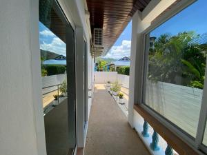 ein Flur eines Hauses mit großen Fenstern in der Unterkunft Villa Jasmine in Rawai Beach