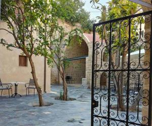 a gate to a courtyard with a table and a tree at Fabrizio del Carretto in Rhodes Town +48 photos