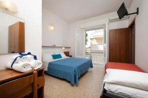 una camera da letto con due letti e un balcone di Hotel Numi a Rimini