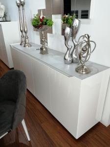 代雷堡Manecas House Creative的一个白色的柜台，上面有银色的雕塑和一把椅子