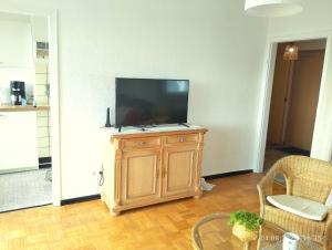a living room with a flat screen tv on a wooden cabinet at Trudi's Apartment bei Bonn in Sankt Augustin