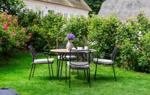 a table with chairs and a vase of flowers on it at Amazing Home In Aabenraa With Wifi in Aabenraa +9 photos